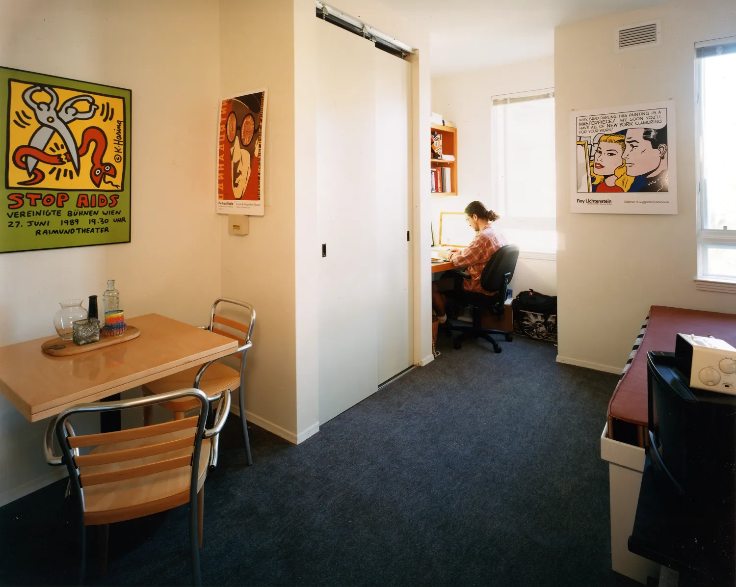 Resident working at his desk in his studio unit at Manville Hall in Berkeley, California.