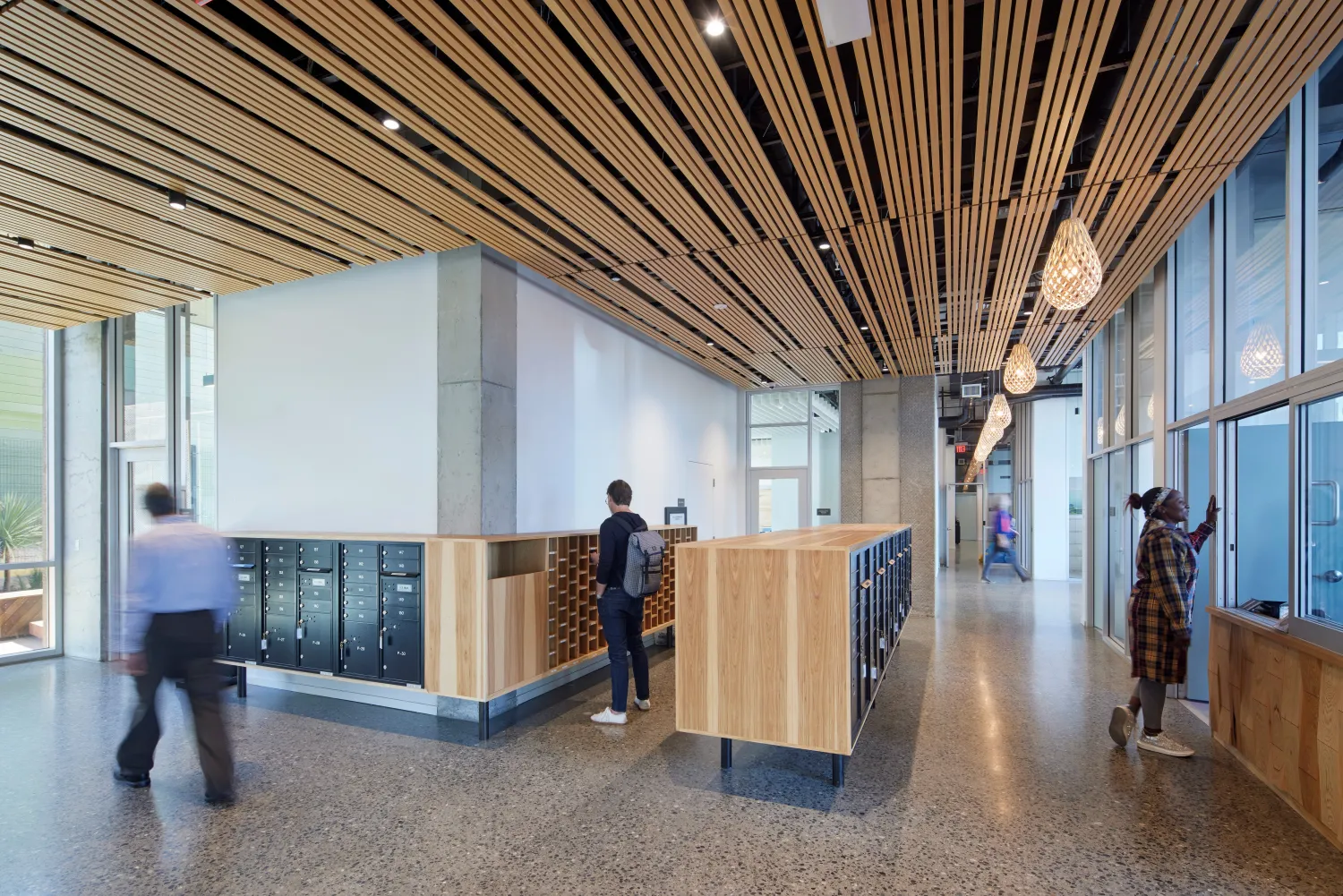 View of lobby with custom wood mailbox enclosures and patterned wood ceiling at Tahanan Supportive Housing in San Francisco.