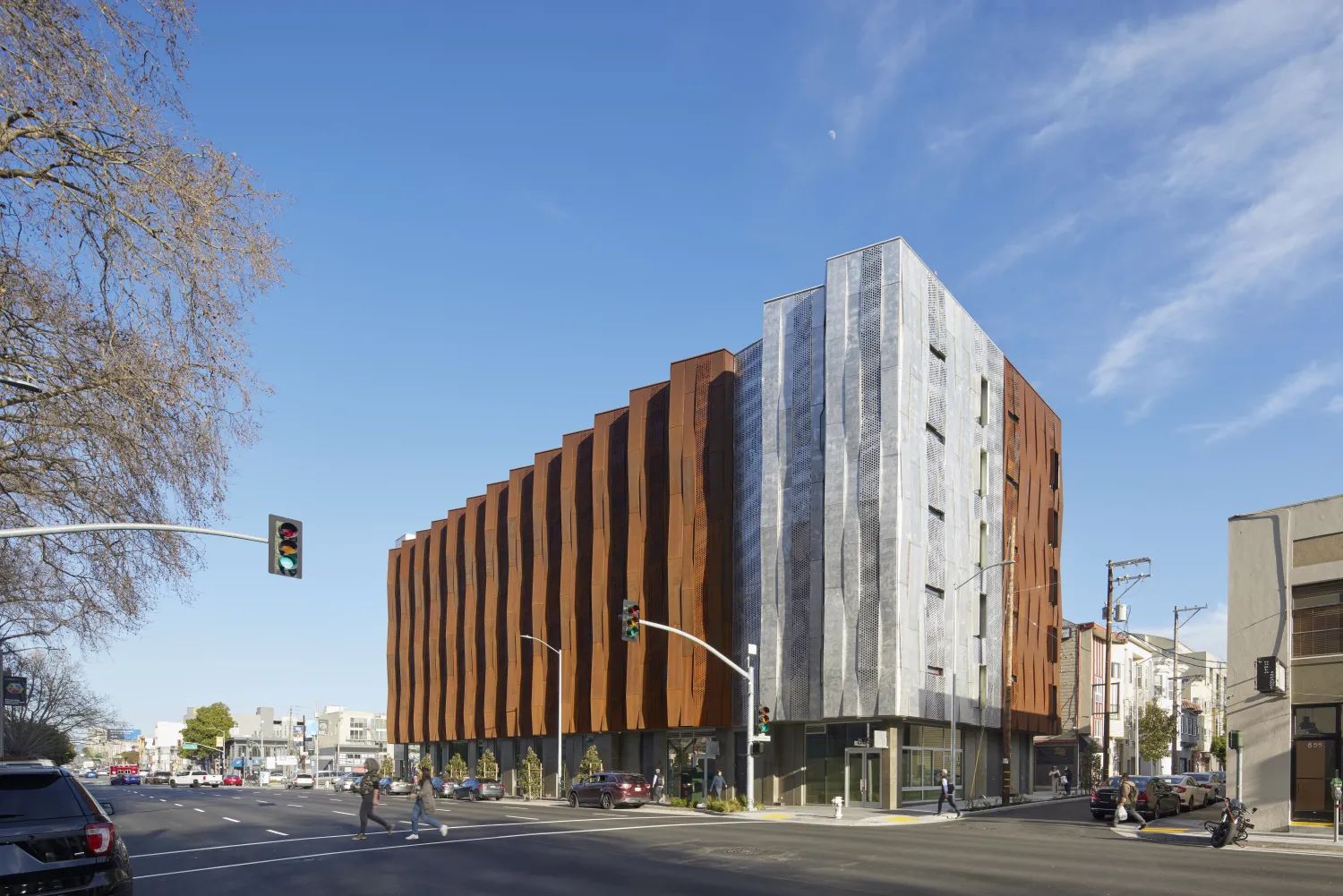 Corner view of Tahanan Supportive Housing with crosswalk in foreground.