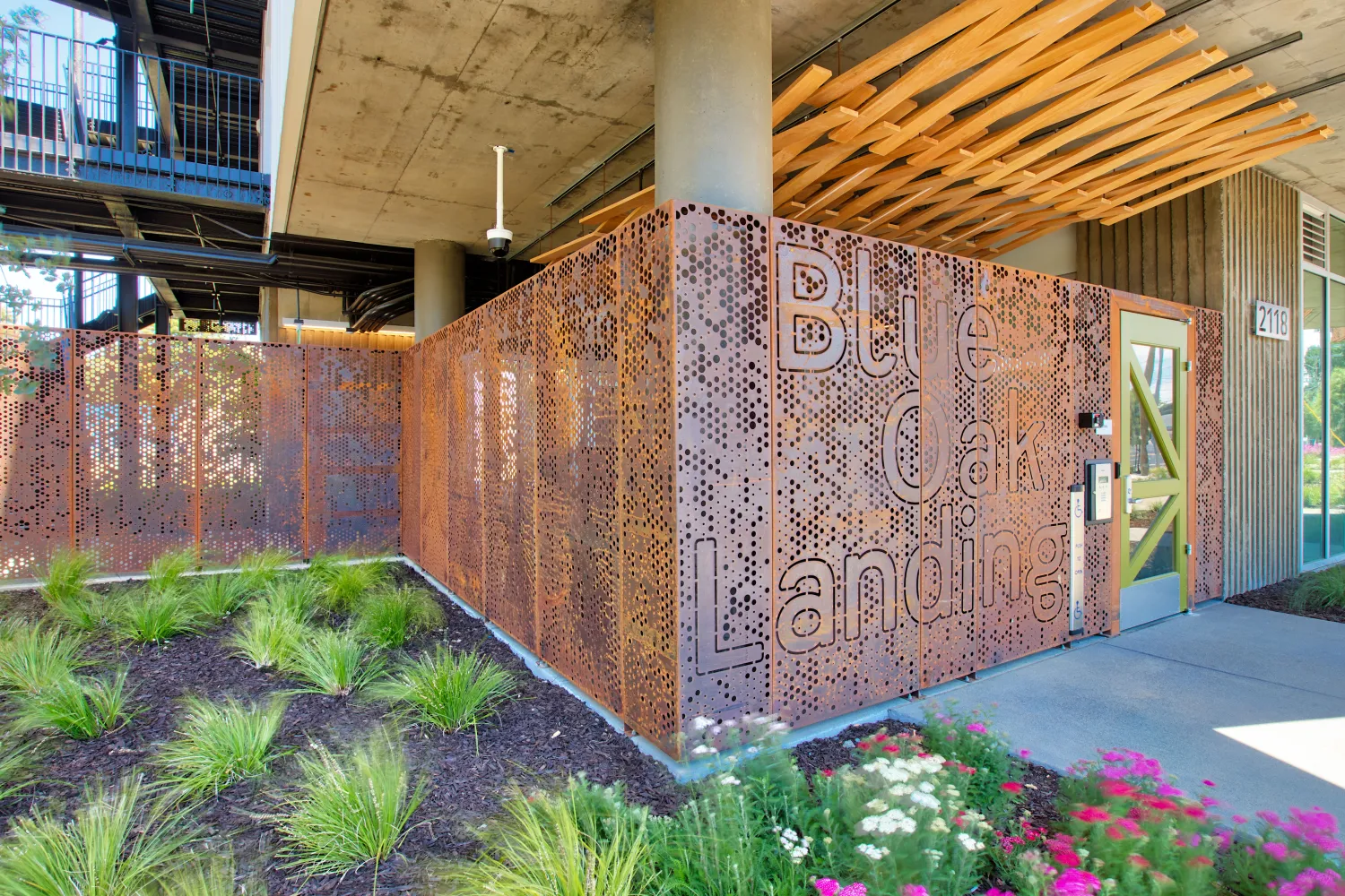 Detail view of greenery in front of the cor-ten steel entry fence at Blue Oak Landing in Vallejo, California.