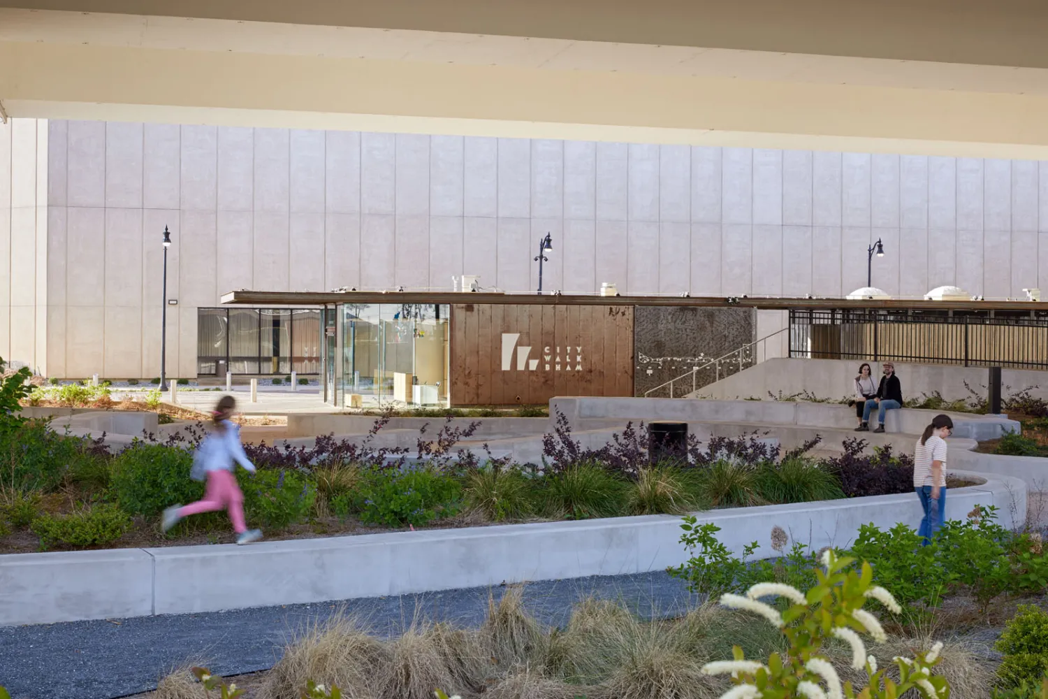 Exterior view of City Walk welcome center with a young girl running by in Birmingham, Alabama.