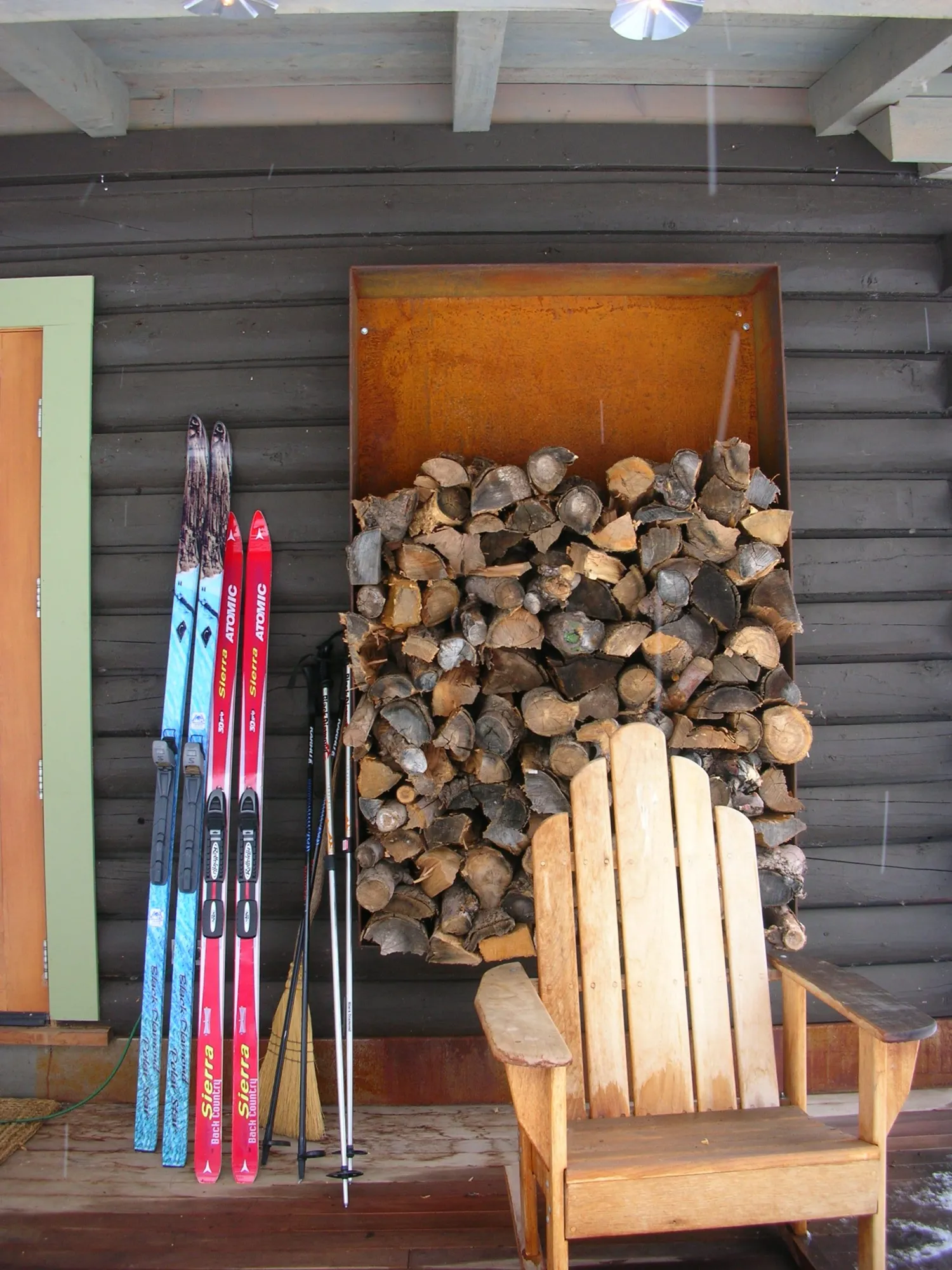 Chair, skis and firewood on the porch of Redstone Cabin in Redstone Colorado.
