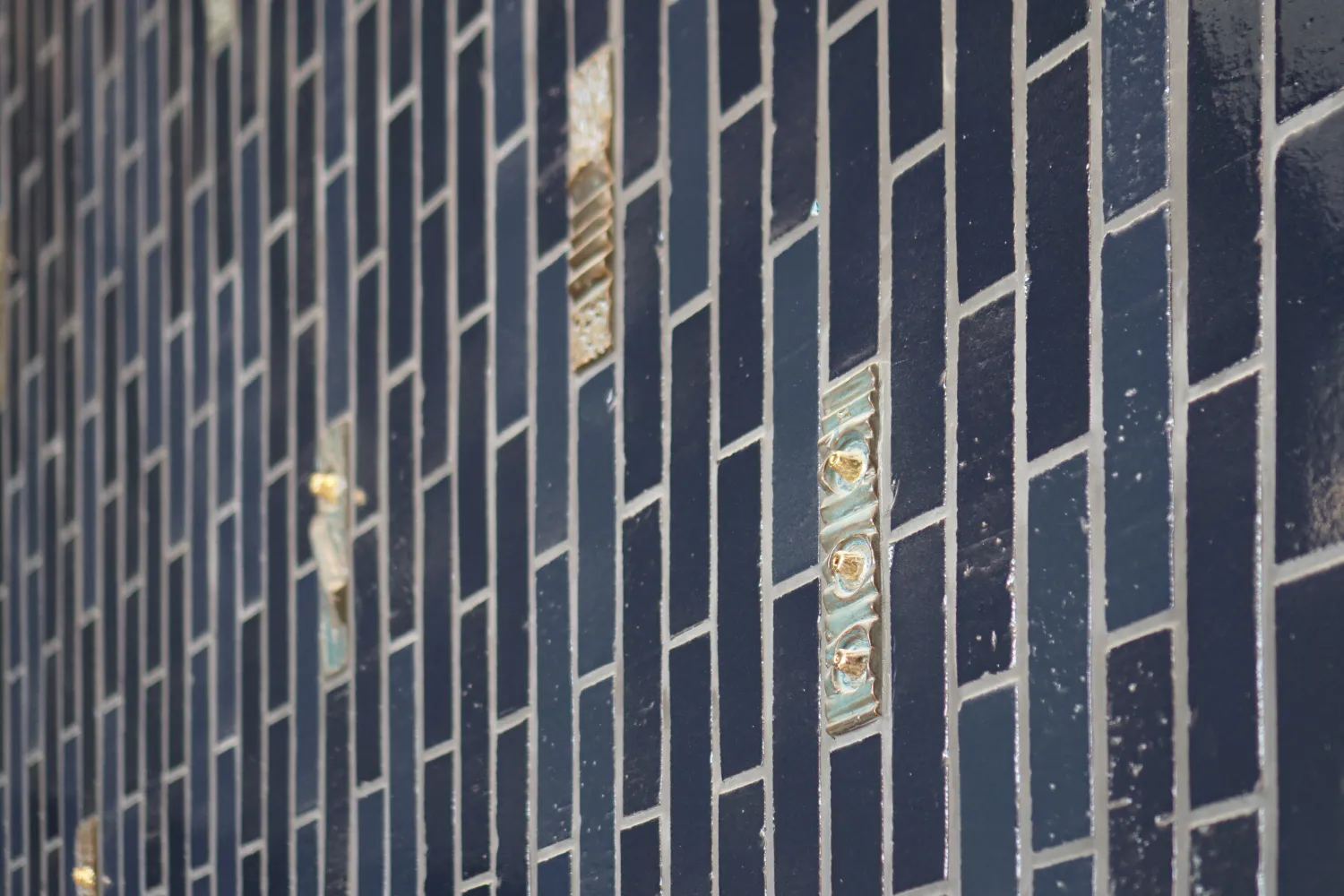 Closeup view of blue tiled wall with custom textured highlight tiles