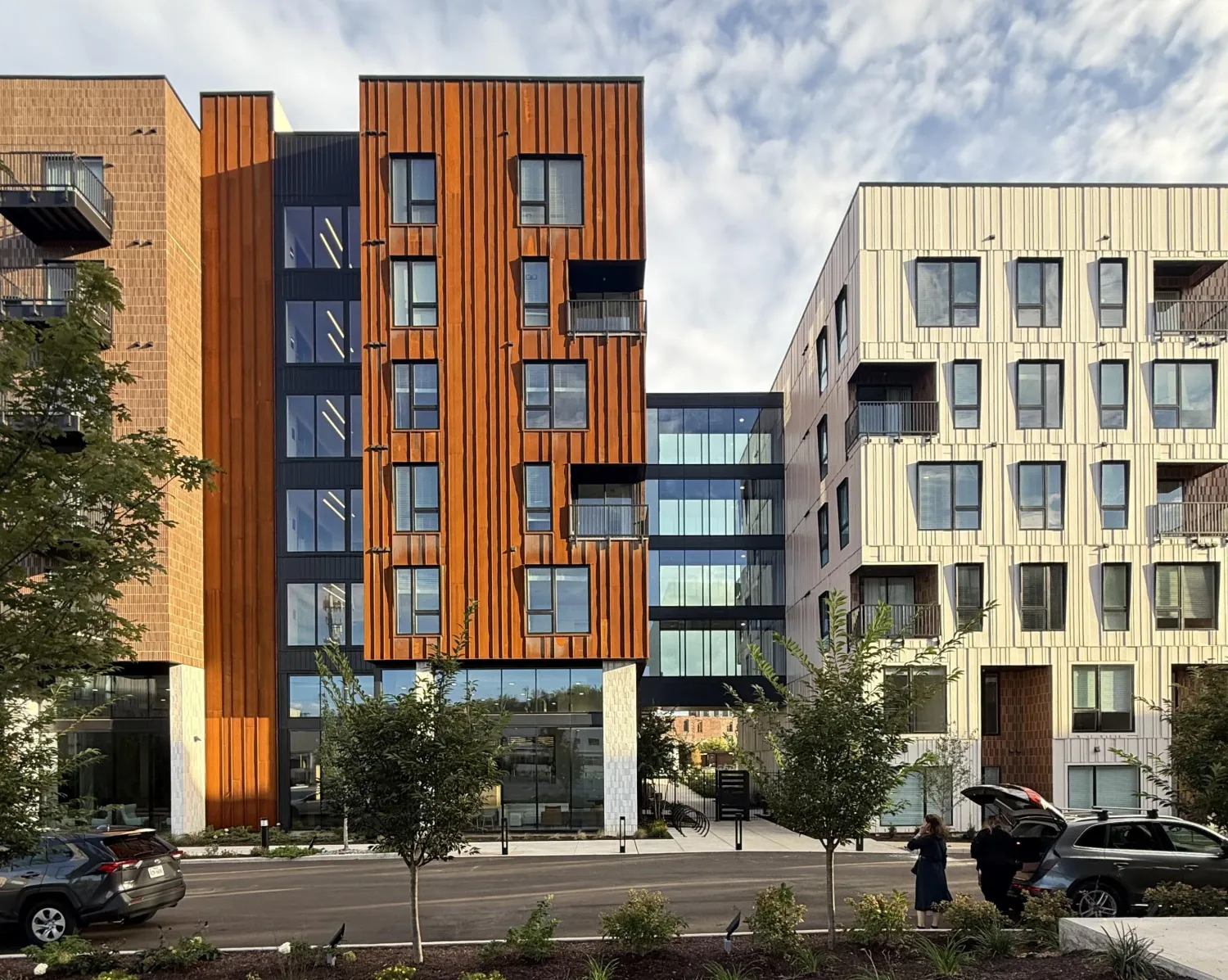 Mid rise building with patinated corten steel across a street