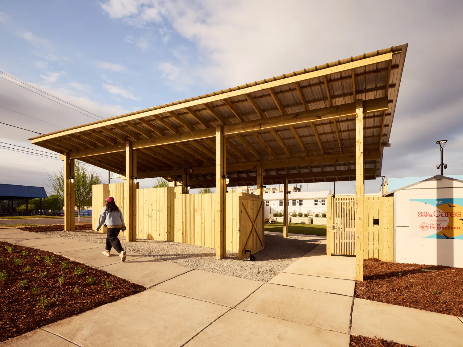 Front sidewalk and shade pavilion over an entry gate