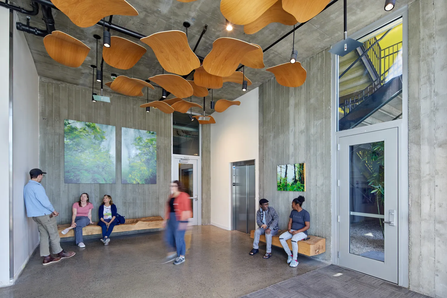 Lobby area with wood ceiling tiles and several people