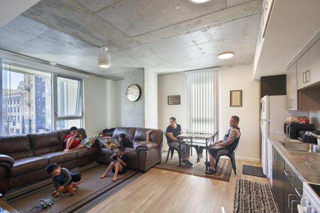 Family gathered in their living room at 222 Taylor Street, affordable housing in San Francisco