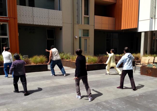 Residents participating in a Tai Chi class in the courtyard of Lakeside Senior Housing in Oakland, Ca