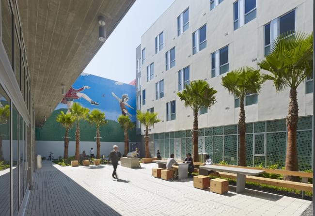 View of Richardson Courtyard from open-air stair, showing mural and people sitting and walking