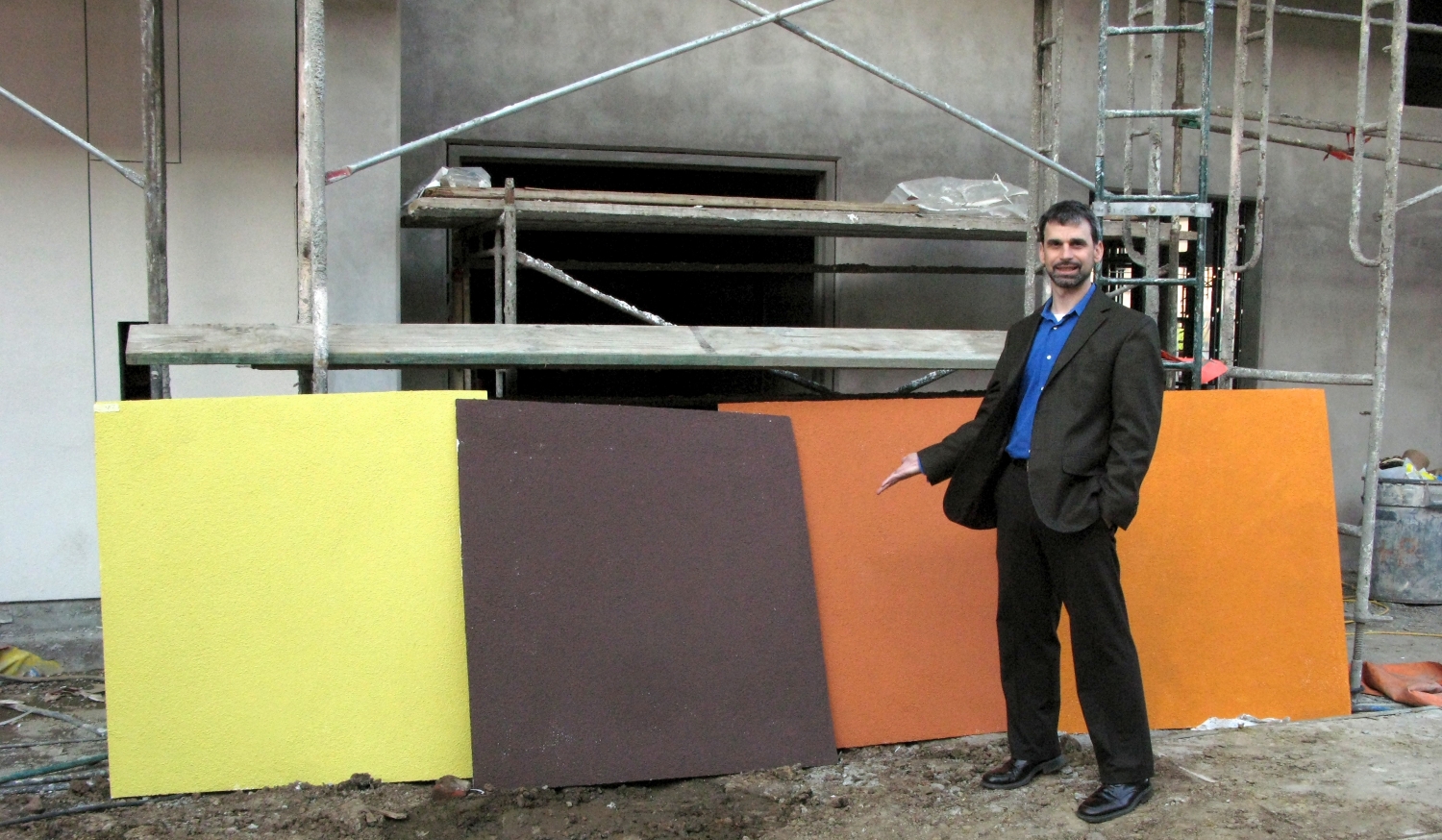Man standing with the fabric wall colors for Armstrong Place Senior in San Francisco.