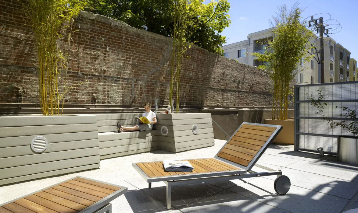 Person siting in the shared courtyard at 200 Second Street in Oakland, California.