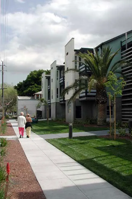 Two people walking on the sidewalk adjacent to View across Lenzen Avenue.