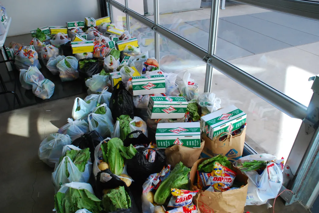 Bags of food bank groceries gathered in the lobby waiting for collection by residents. 