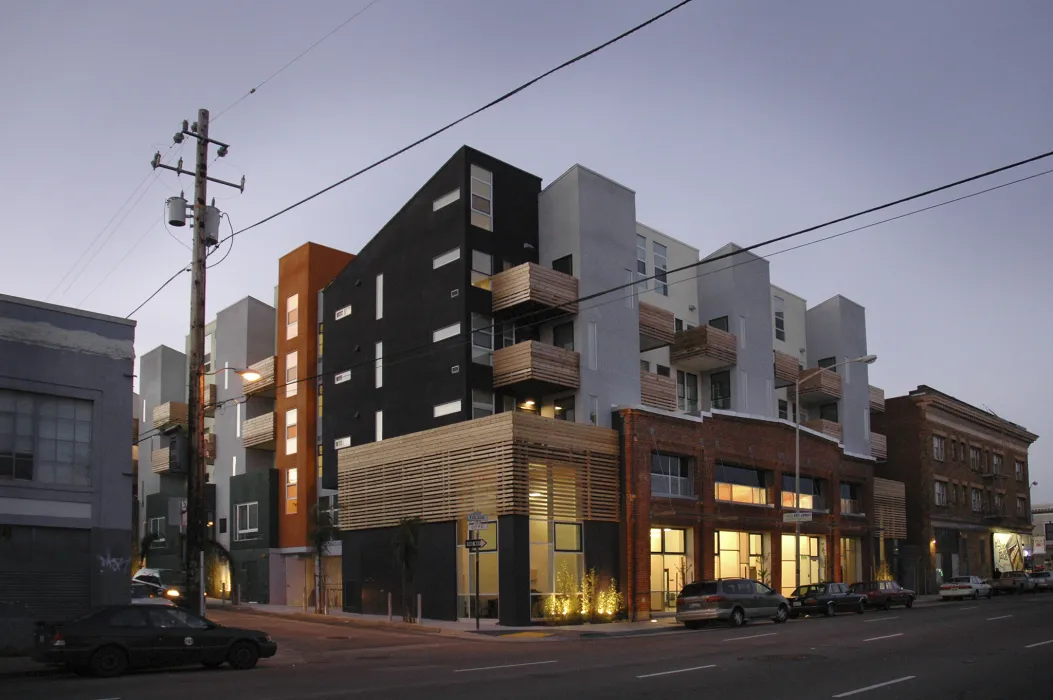Exterior street view at dusk of Folsom-Dore Supportive Apartments in San Francisco, California.