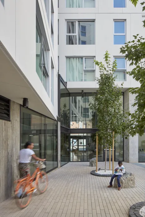 Women walking her bike in the courtyard of 222 Taylor Street, affordable housing in San Francisco