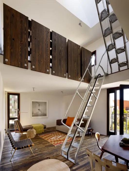 Interior view of the entrance, living room and second and third level metal stairs inside Zero Cottage in San Francisco.