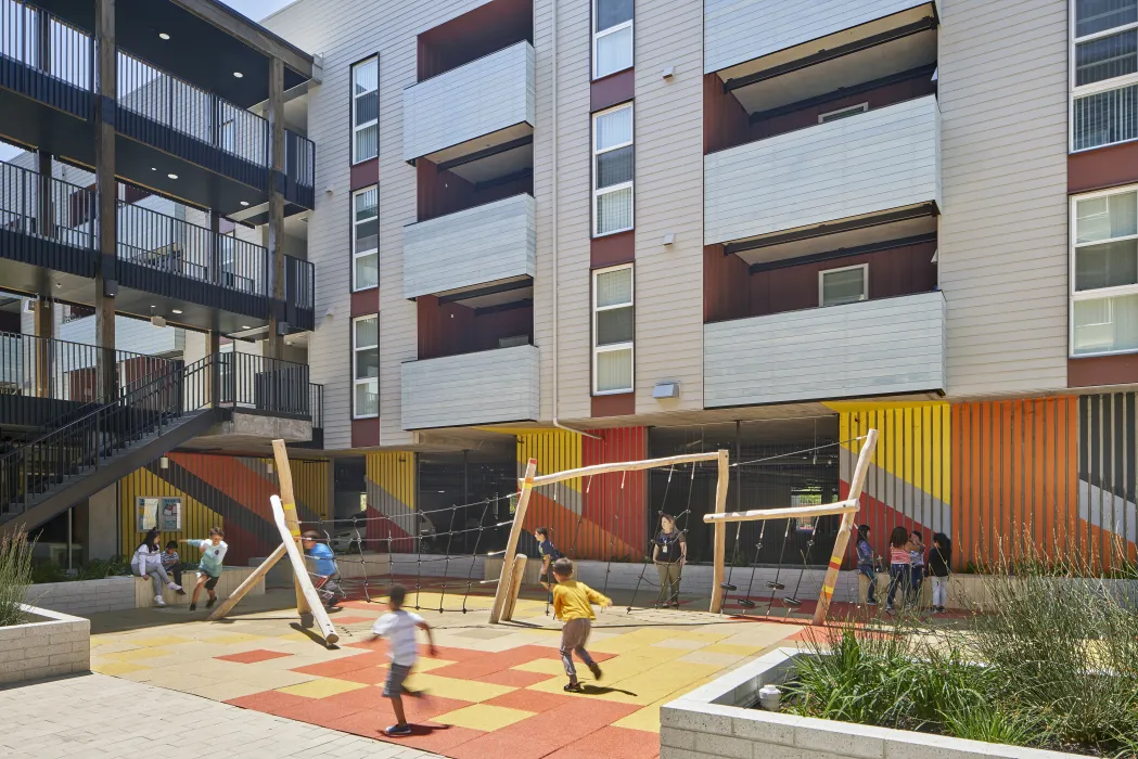 Children playing in the courtyard playground in Edwina Benner Plaza in Sunnyvale, Ca.