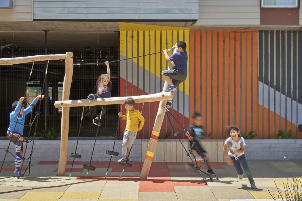 Children playing in the courtyard playground in Edwina Benner Plaza in Sunnyvale, Ca.