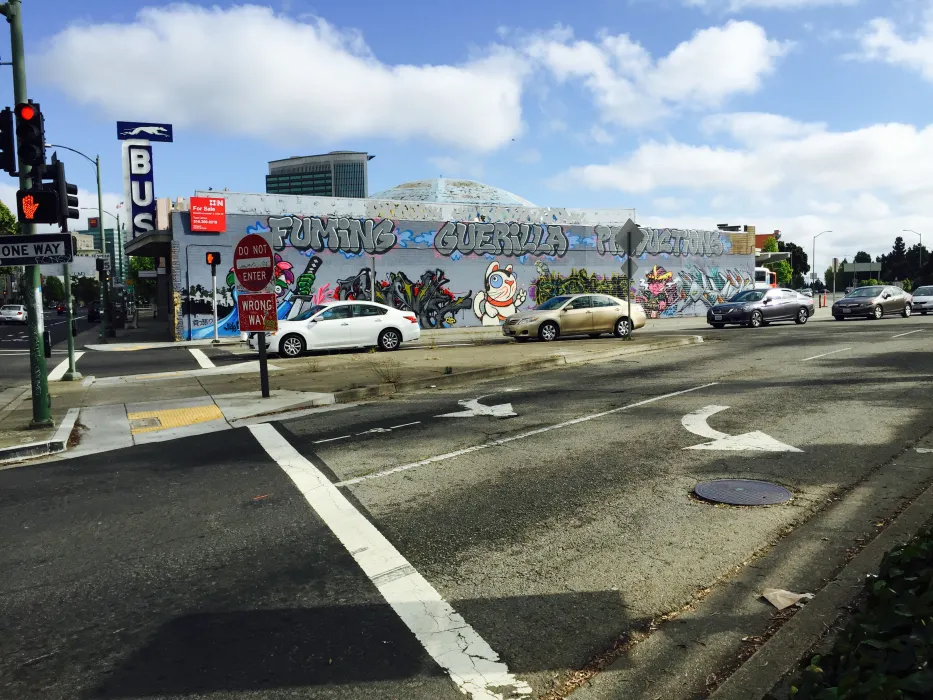 Exterior street view of the side of David Baker Architects Office covered in street art in Oakland, California.