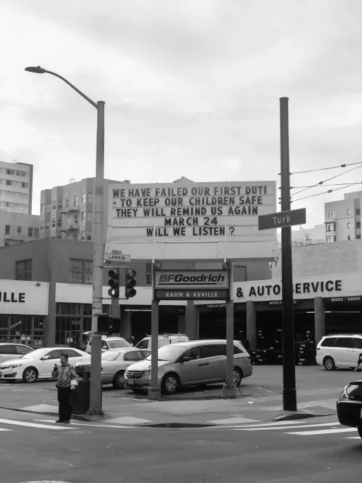 Sign at previous 555 Larkin site that states "We have failed our first duty. To keep our children safe. They will remind us again. March 24. Will we listen?"