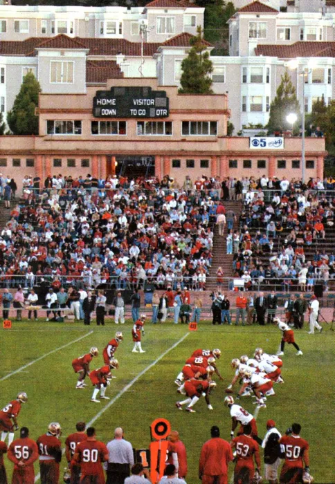 Football stadium with people in the stands and Parkview Commons in the background.