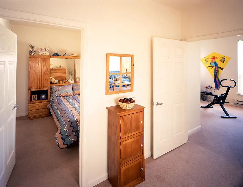 View into apartment bedroom and living room at Plaza Maria in San Jose, California.