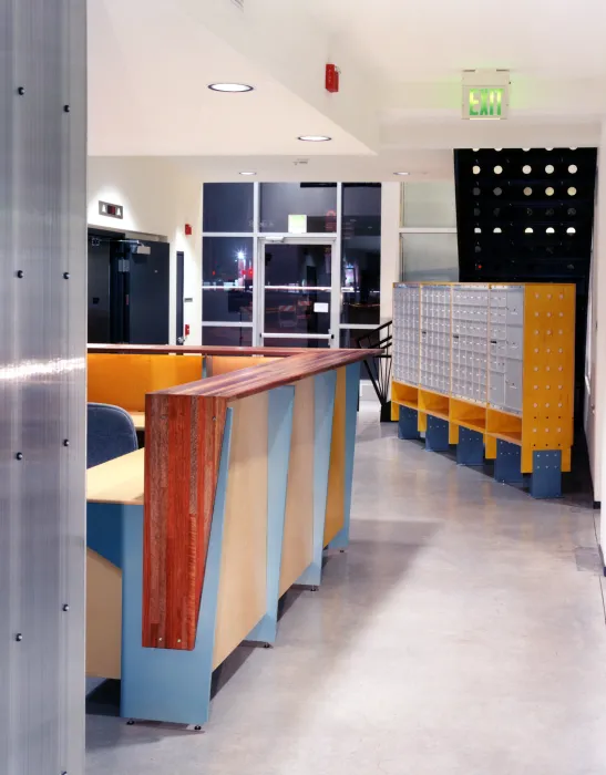 Entry lobby at night with the reception desk and mailboxes at Pensione Esperanza in San Jose, California.