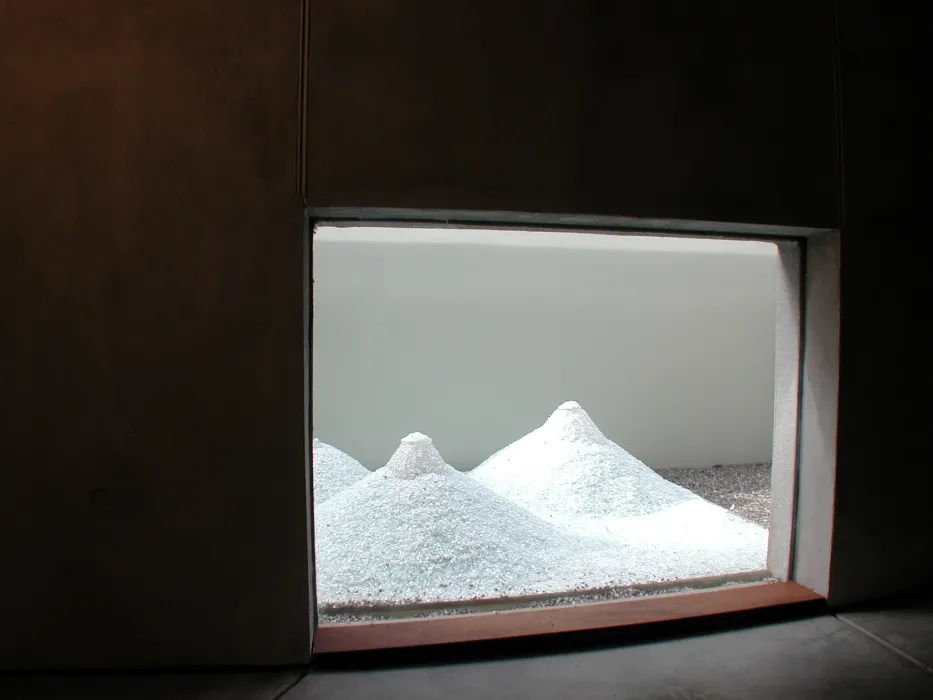 Looking through a window to an art installation small white mountains at 310 Waverly Residence in Palo Alto, California.