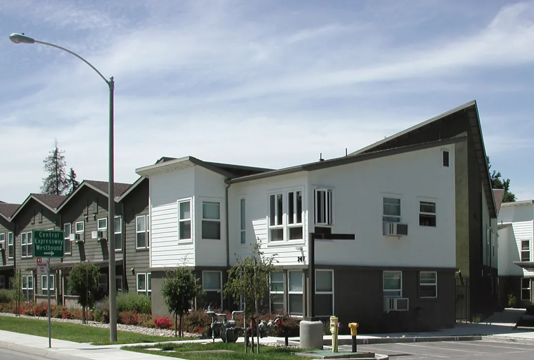 Exterior view of the community building and surface parking at Stoney Pine Villa in Sunnyvale, California.