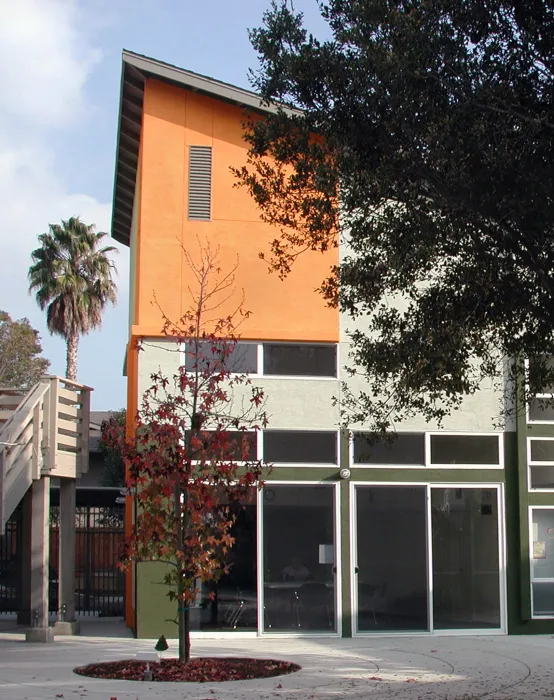 Exterior view of the colorful community building and courtyard at Stoney Pine Villa in Sunnyvale, California.