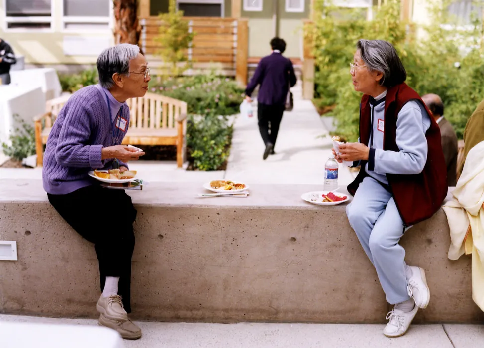 Two residents sitting in the courtyard at Mabuhay Court in San Jose, Ca.