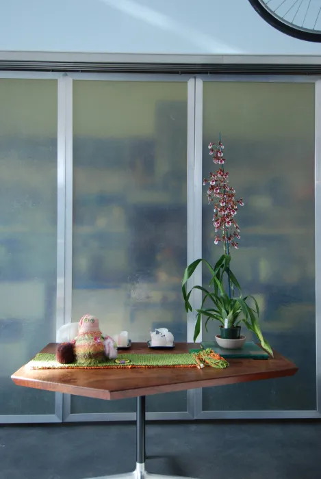 A walnut table with flowers sitting on top at Shotwell Design Lab in San Francisco.