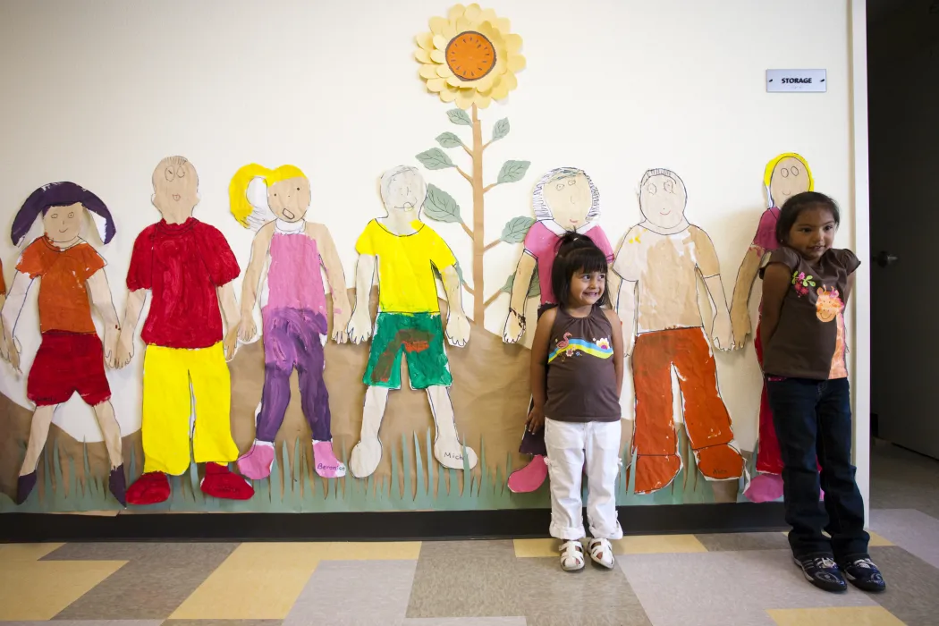 Two children standing in front of art at Paseo Senter in San Jose, California.