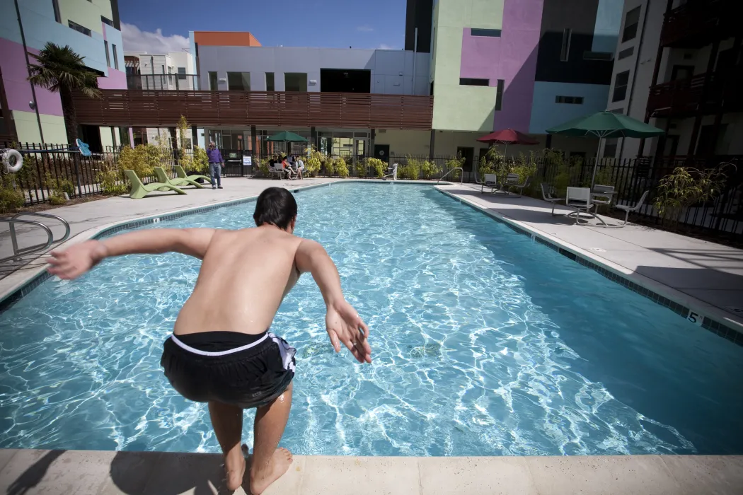 Man jumping into the pool at Paseo Senter in San Jose, California