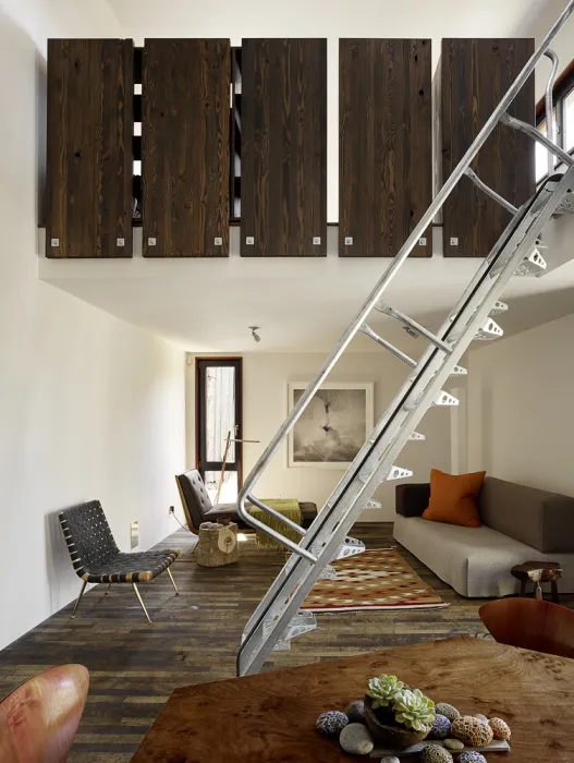 Interior view of the living room and metal stairs inside Zero Cottage in San Francisco.