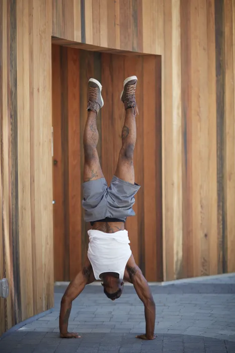 Resident doing handstand in the courtyard of Bayview Hill Gardens in San Francisco, Ca.