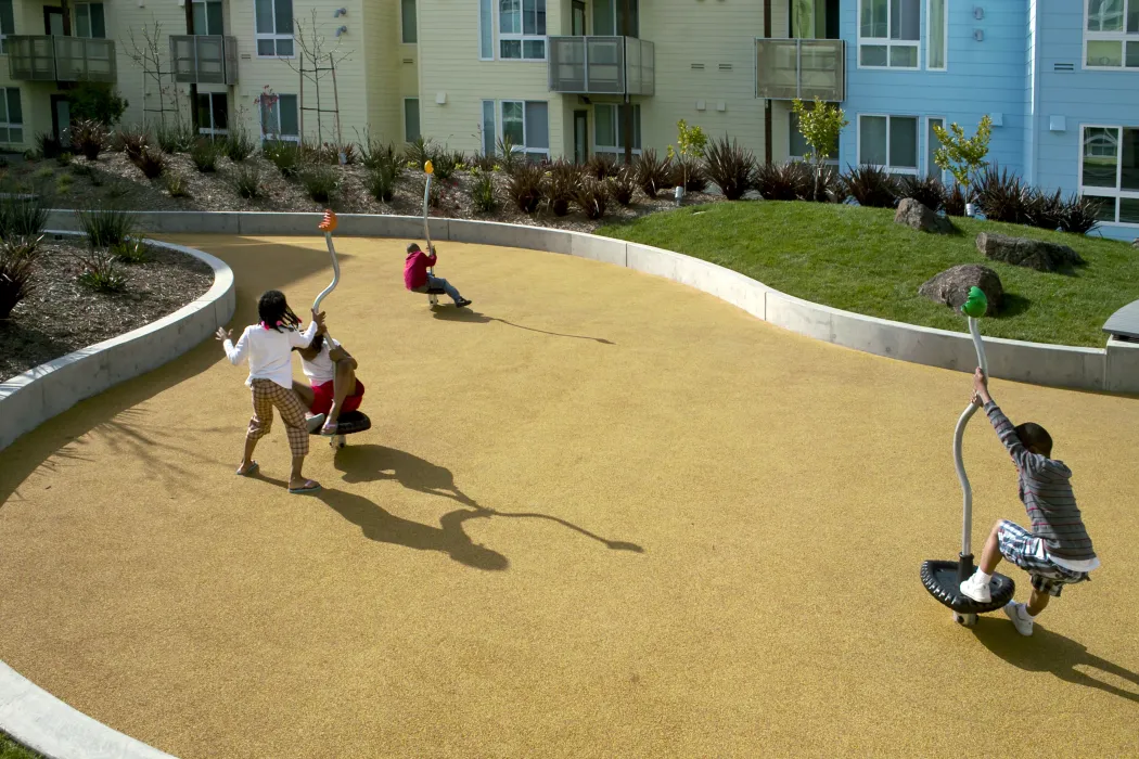 Kids playing at the play area in the resident courtyard at Ironhorse at Central Station in Oakland, California.