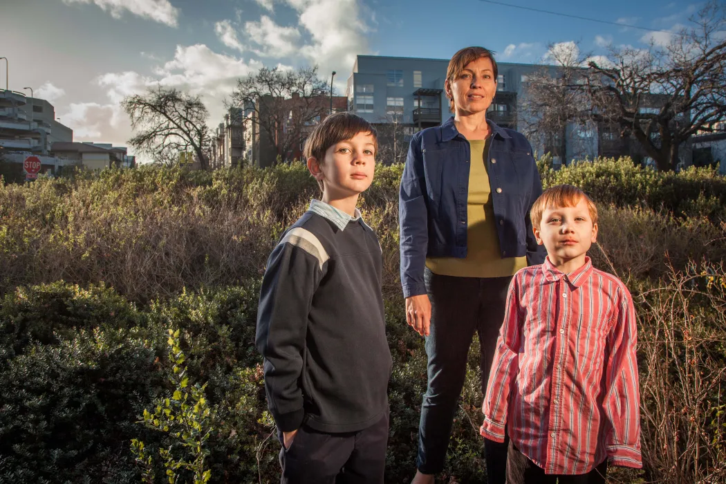 Resident and her two children standing with Coggins Square in Walnut Creek, California in the background.