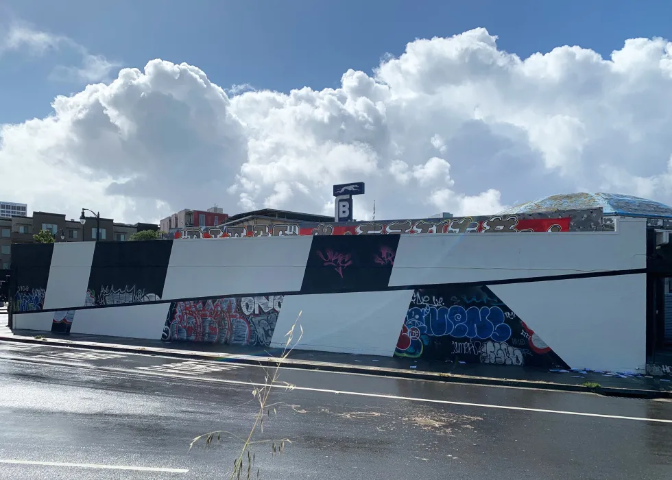 Exterior street view of the side of David Baker Architects Office covered in street art in Oakland, California.