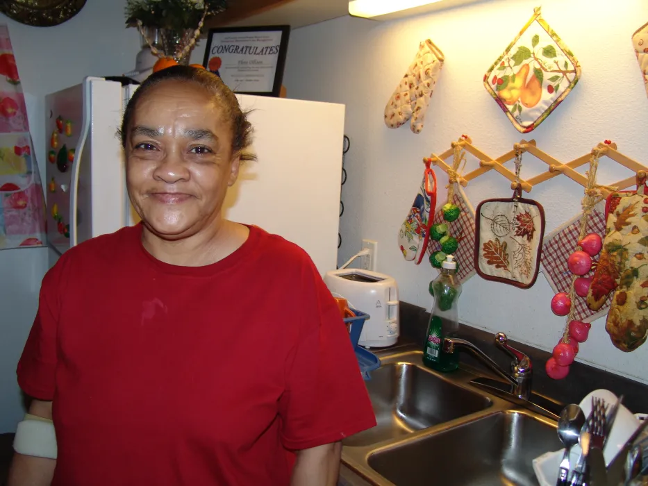 A woman standing in her kitchen at Folsom-Dore Supportive Apartments in San Francisco, California.