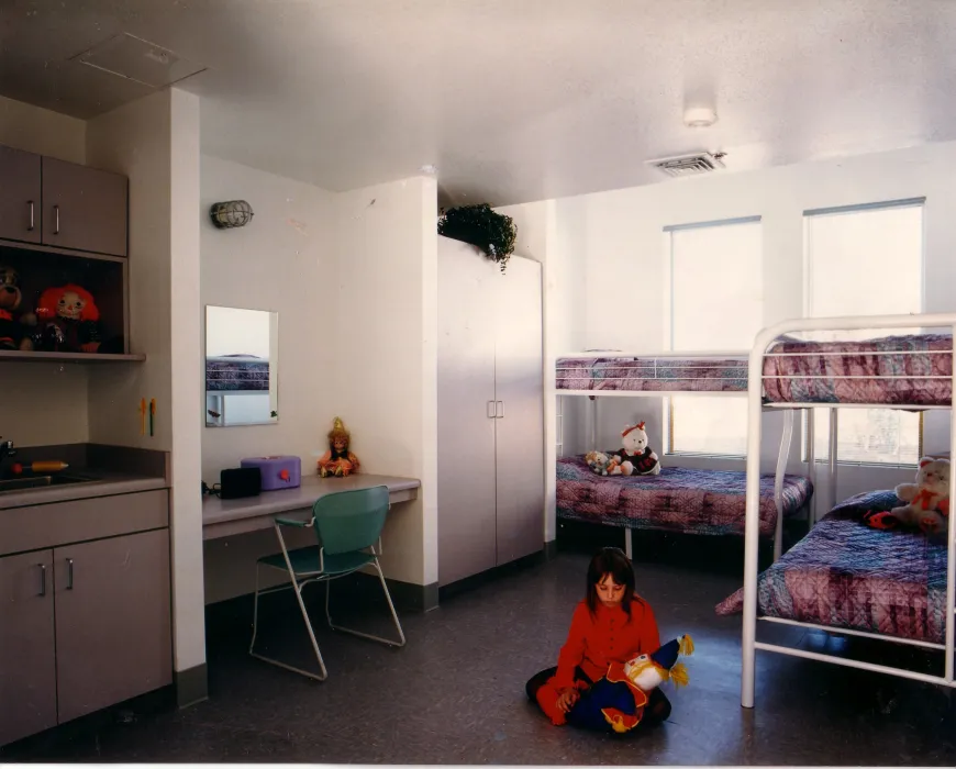 Child playing in a room with four bunkbeds at Sunrise Village in Fremont, California.
