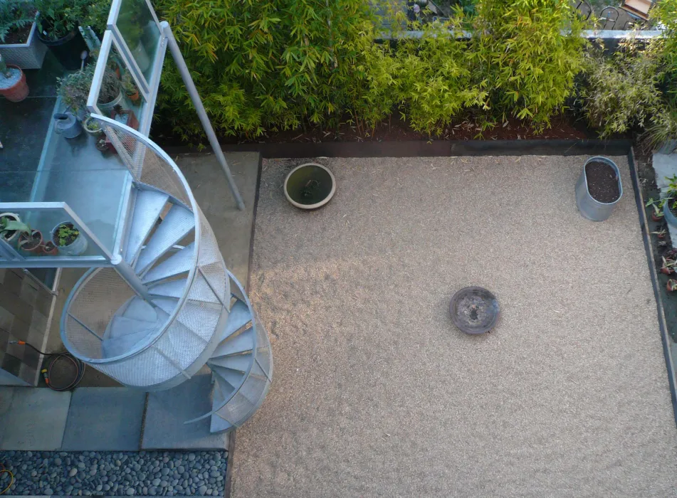 Looking down to the courtyard with the deck and spiral stairs in partial view at Shotwell Design Lab in San Francisco.