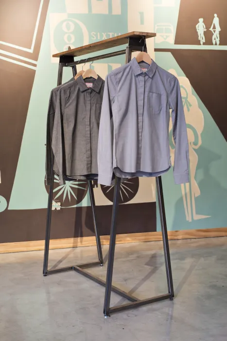 Detail of shirts hanging from a merchandise fixture inside Huckleberry Bicycles in San Francisco.