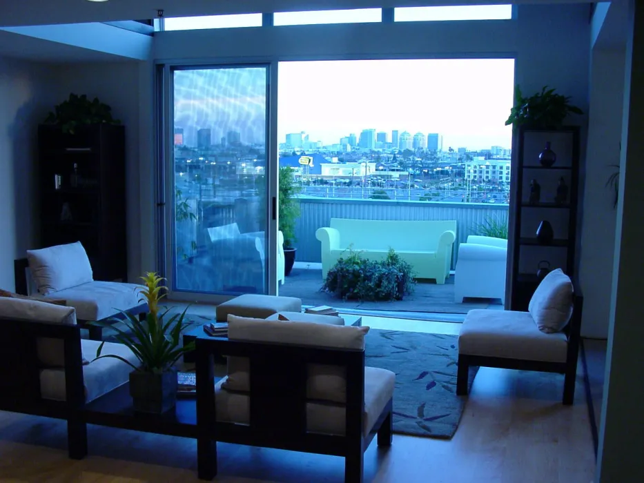 Interior view of a unit living room and balcony at 1500 Park Avenue Lofts in Emeryville, California.