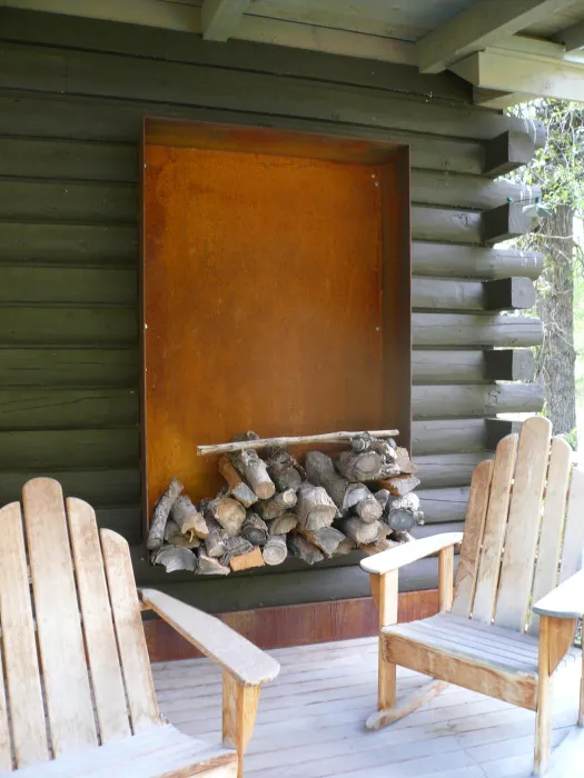 Two chairs and firewood on the porch of Redstone Cabin in Redstone Colorado.