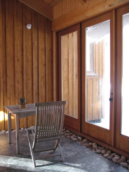 A sunroom with a table and chair at Redstone Cabin in Redstone Colorado.