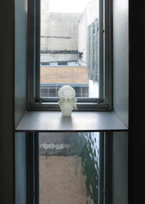 A pivot window in closed position with a small astronaut figurine on it at Shotwell Design Lab in San Francisco. 