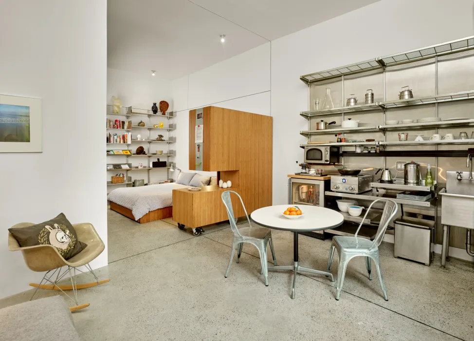 Interior view of the kitchen and dining area with sleeping area in the background in Shotwell Garden Retreat in San Francisco.