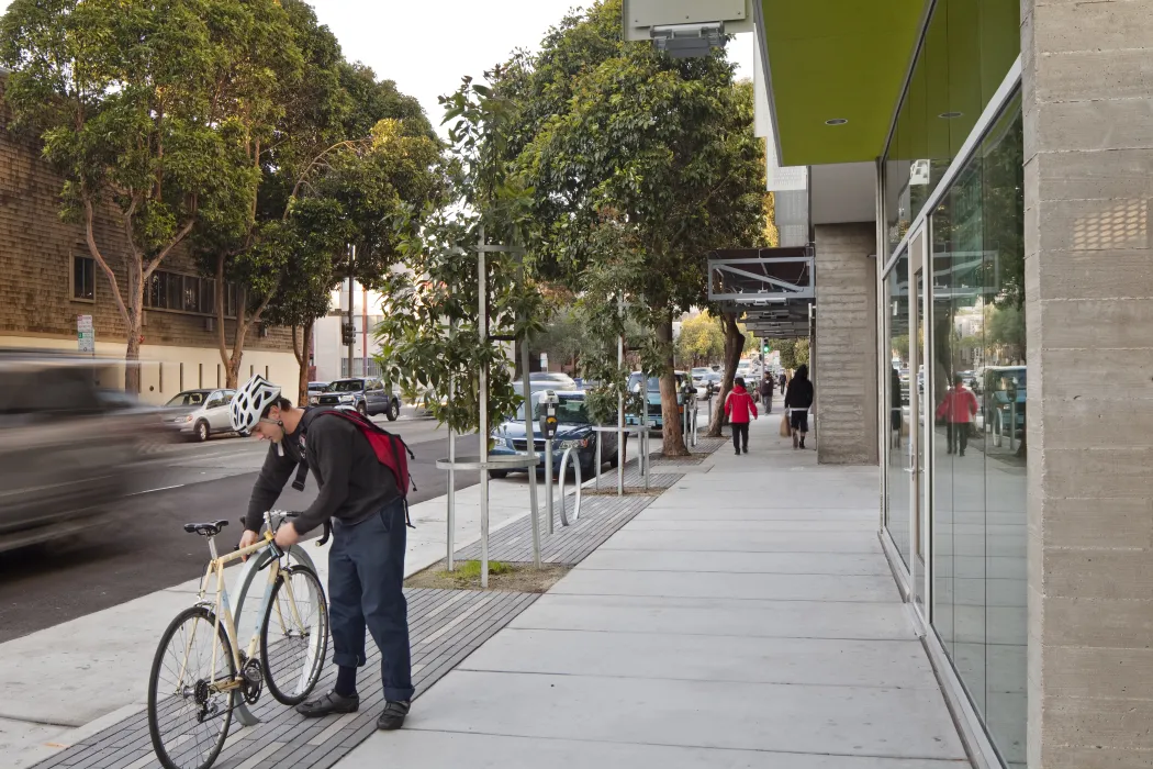 Person locking bike outside Richardson Apartments in San Francisco.