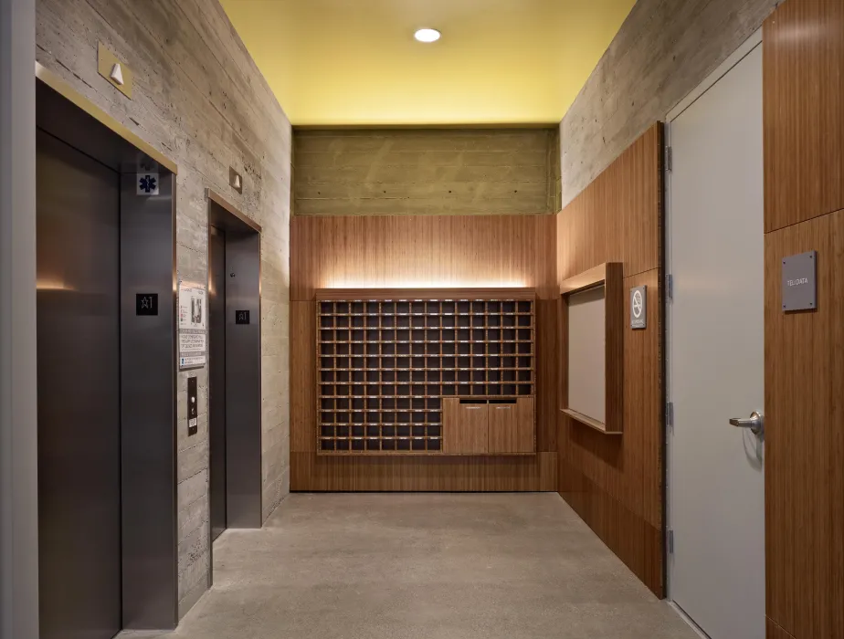 Custom plyboo mail cubbies in the elevator lobby of Richardson Apartments in San Francisco.